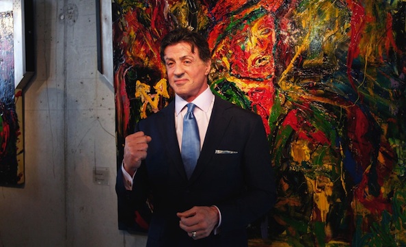 Sylvester Stallone in front of his art